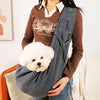 A person is holding a gray portable pet carrier sling bag with a fluffy white dog in the carrier.