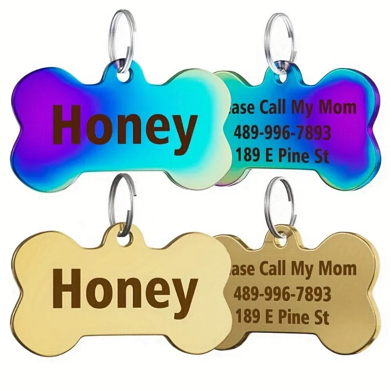 Two bone-shaped stainless steel pet ID tags, one purple and one gold, with contact information engraved.