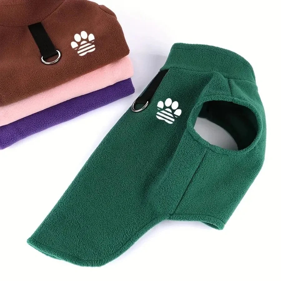 A green fleece dog sweater with a paw print design shown next to stacked sweaters.