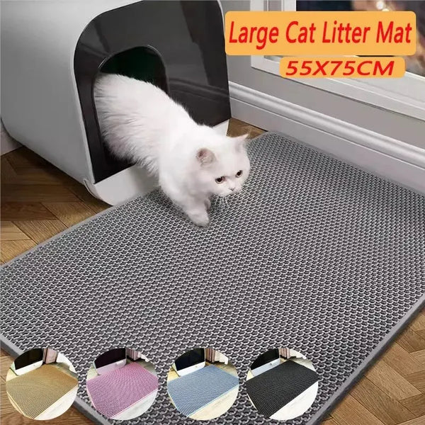Un chat blanc se tient sur un tapis de litière gris à double couche devant une litière.