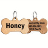A tan bone-shaped stainless steel pet ID tag with the name Honey and contact information engraved on it.
