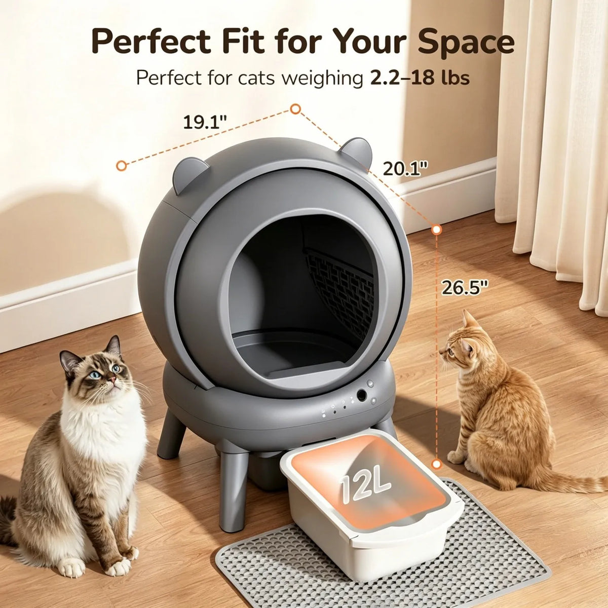 A gray automatic self-cleaning cat litter box sits on a mat next to a cat, demonstrating its fit for small spaces.
