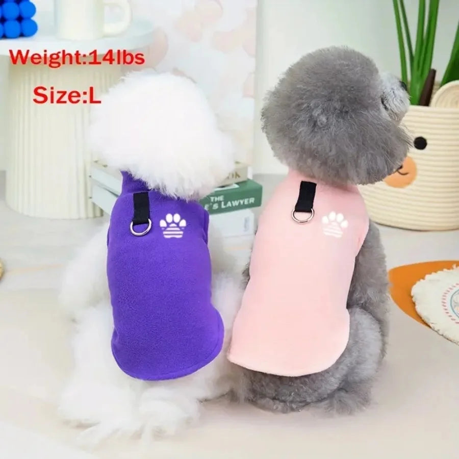 A gray plush dog wearing a purple fleece sweater and a white fluffy dog wearing a pink fleece sweater.