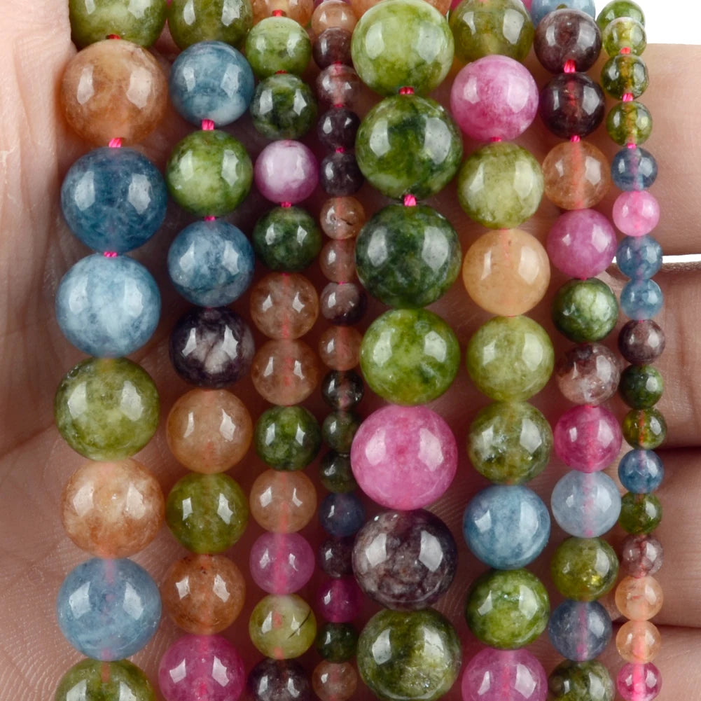 A close-up of a string of natural stone beads in various colors and sizes for jewelry making
