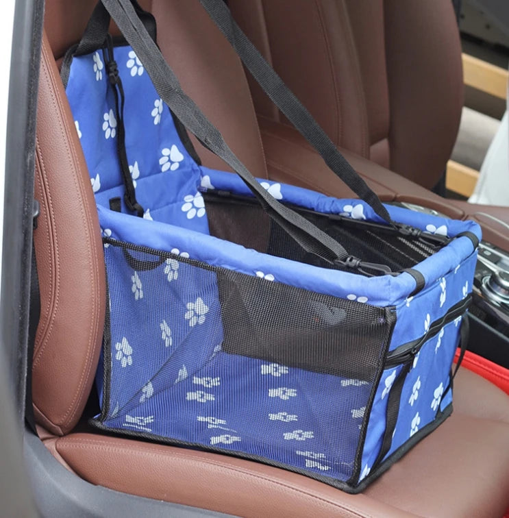 Siège de transport pliable pour animaux à motifs bleu et blanc, montré dans un siège de voiture marron.