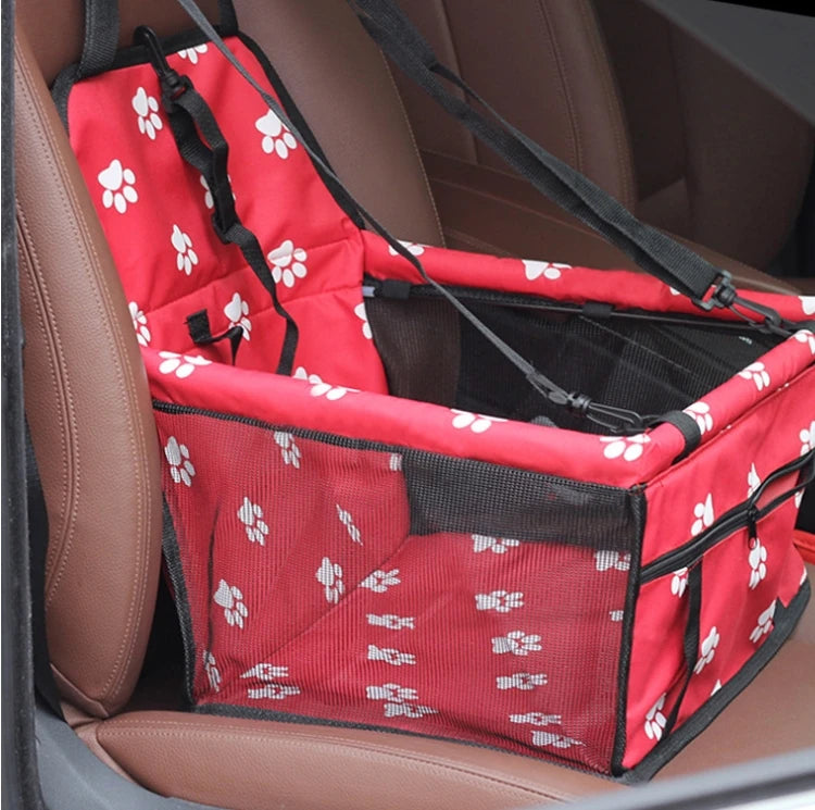 Siège de transport pliable pour chien à motifs rouge et blanc, montré dans un siège de voiture.