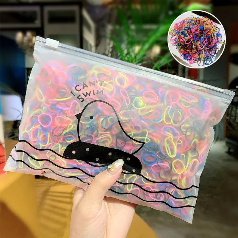 Klare Plastiktüte mit bunten Gummibändchen in Form eines Enten, schwimmend im Wasser.