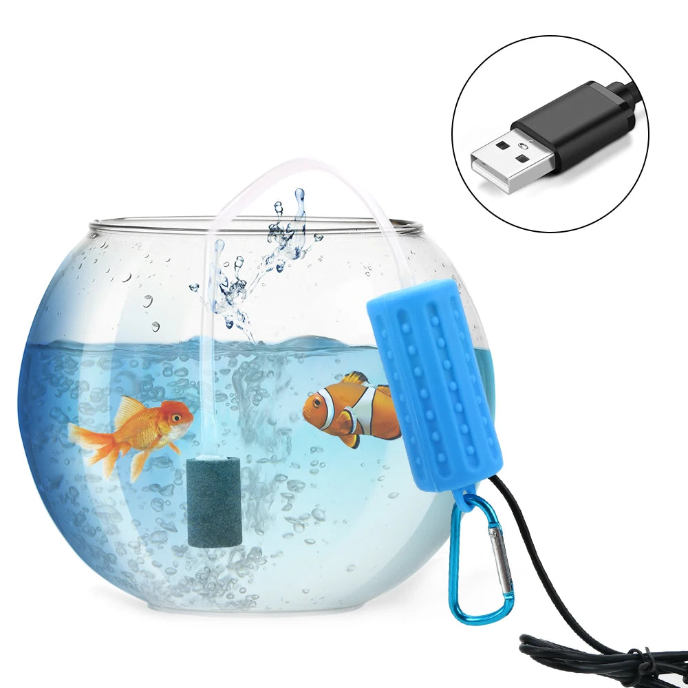 A clear glass aquarium with a fish, connected to a blue air pump and a USB cable.