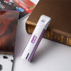 A white electric pet grooming clipper is placed on a brown book next to a picture of a dog.