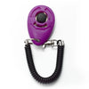 A purple pet training clicker with a black sensor attached to a black wrist strap.