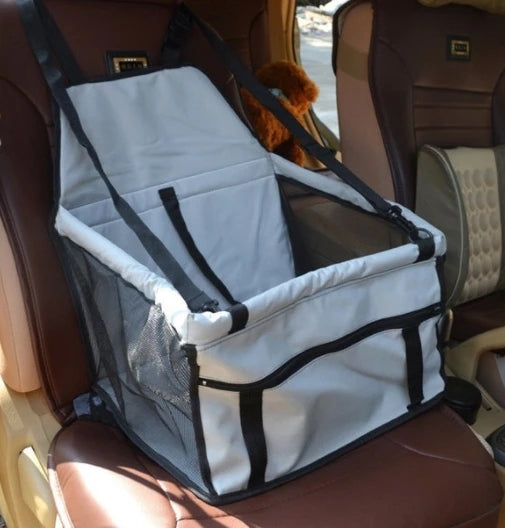 Siège de transport pliable pour animaux, blanc et noir, installé dans un siège de voiture.
