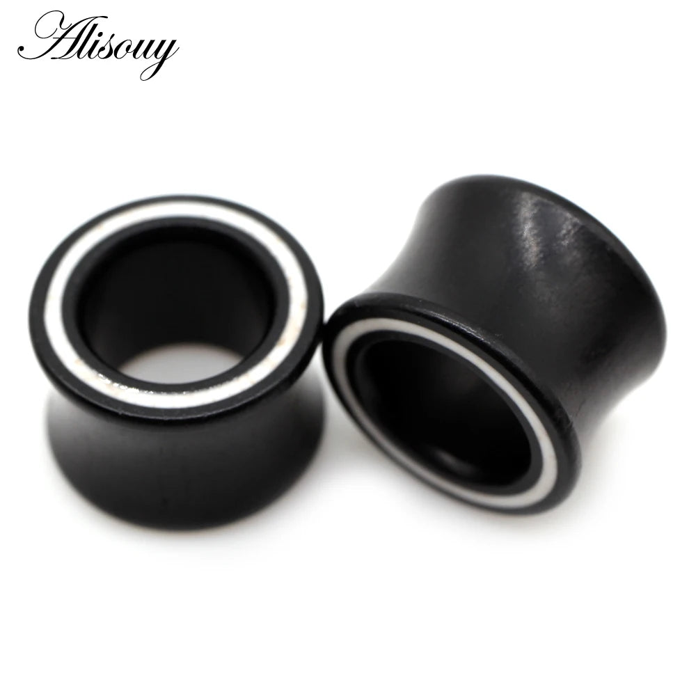 Black wood ear tunnels with a white inlay shown against a white background.