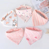 A set of five pink cotton triangle baby bibs featuring various cartoon prints and patterns.