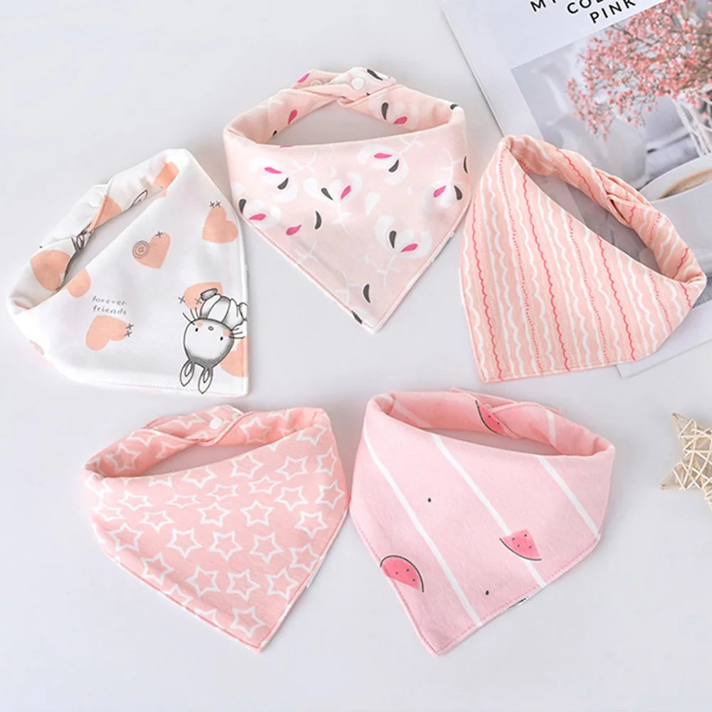 A set of five pink cotton triangle baby bibs featuring various cartoon prints and patterns.