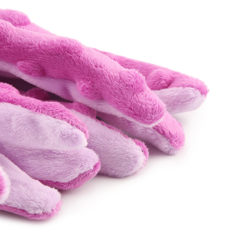 A close-up of several fuzzy pink and lavender interactive squeak dog toys.