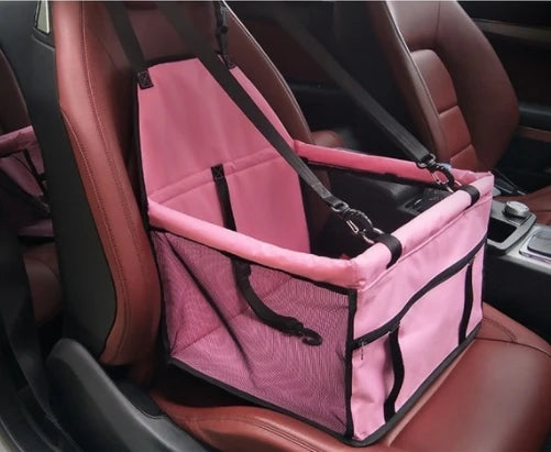 Siège de transport pliable pour animaux rose et noir installé dans un siège de voiture, prêt à l'emploi.