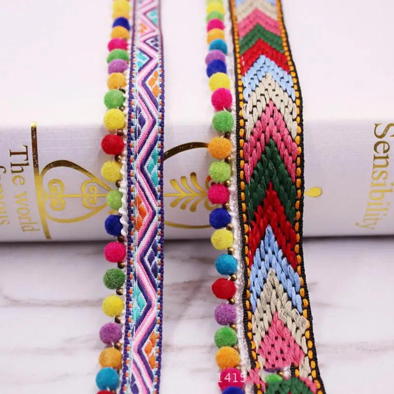 Close-up of colorful pearl pom pom fringe lace trim in various shades and patterns for sewing and DIY crafts