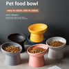 A collection of matte ceramic pet food bowls in various colors, including yellow, black, and pink, displayed on a gray surfac