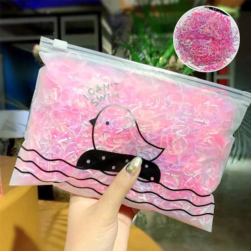 Klare Plastiktüte gefüllt mit rosa Gummibändchen und einer schwarzen Enten-Grafik.