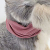 A dog wearing a pink soundproof ear muff covering its ears.