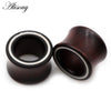 A dark brown wooden ear tunnel with a white inlay, shown against a white background.