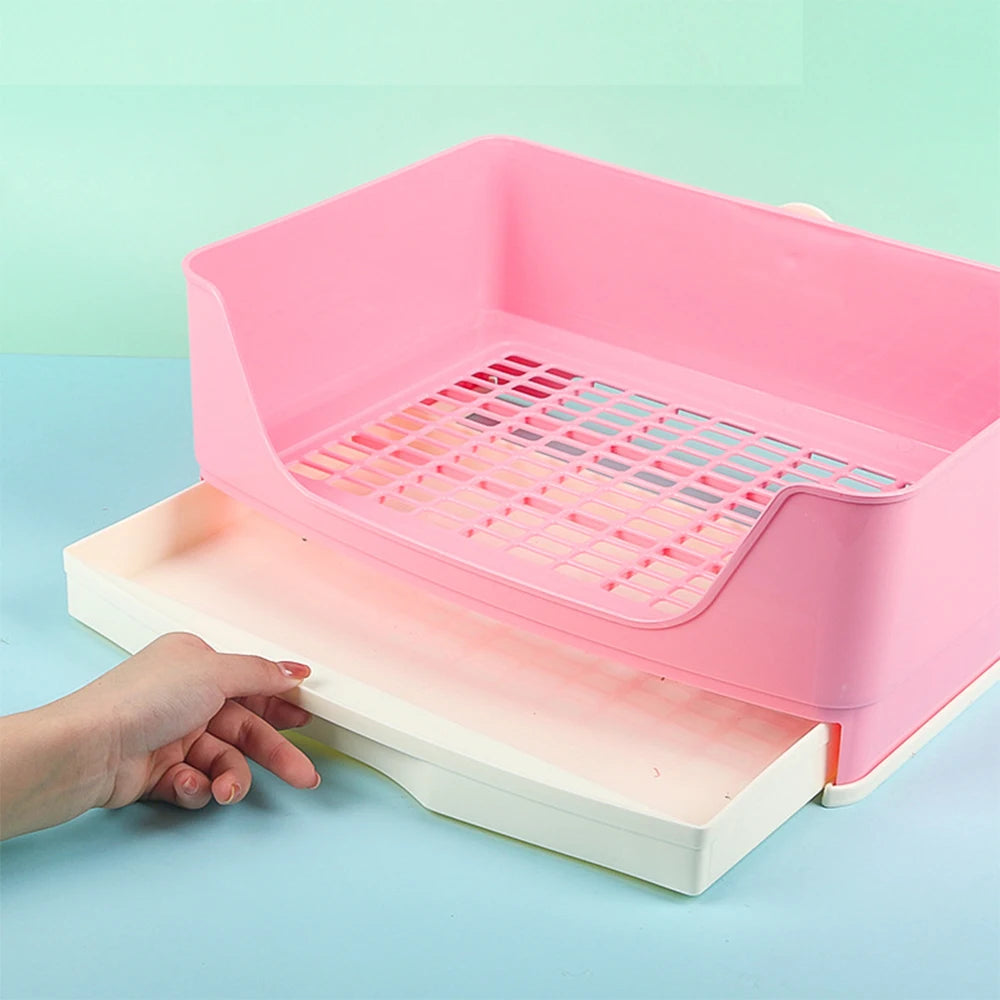 A pink anti-overturn drawer litter box is shown open, with a hand resting on the white base.