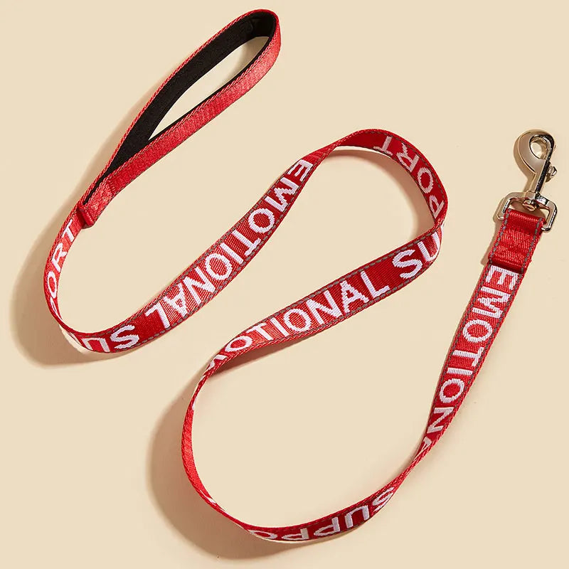 A red reflective service dog leash with a padded neoprene handle is shown against a light background.