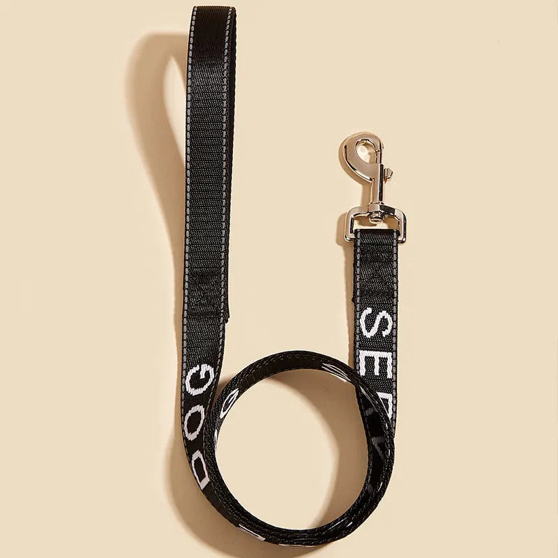 A black reflective service dog leash with a padded neoprene handle and metal clip.