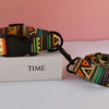 A colorful printed dog collar and leash set resting on a white box with the word TIME.