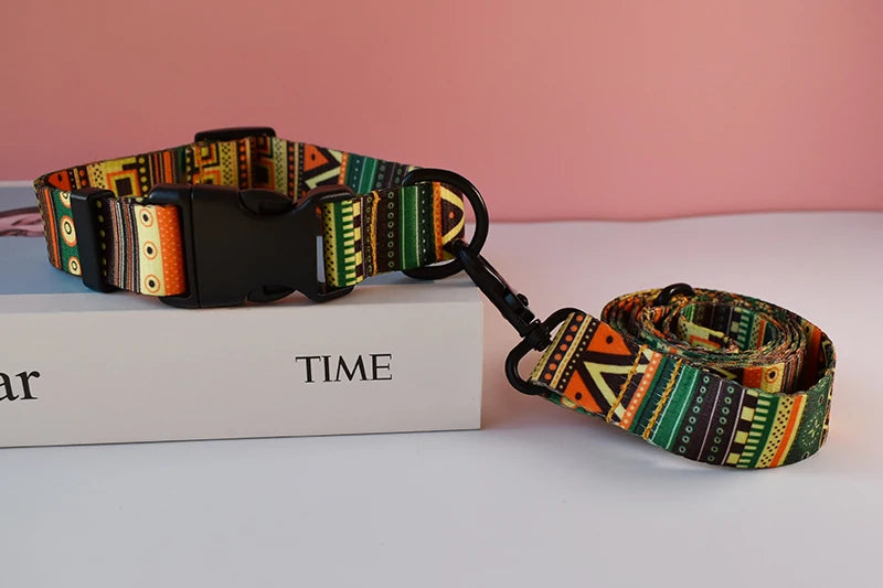 A colorful printed dog collar and leash set resting on a white box with the word TIME.