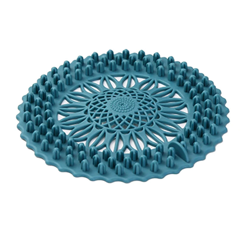 A teal silicone drain cover with a handle, featuring a textured pattern for hair and debris.