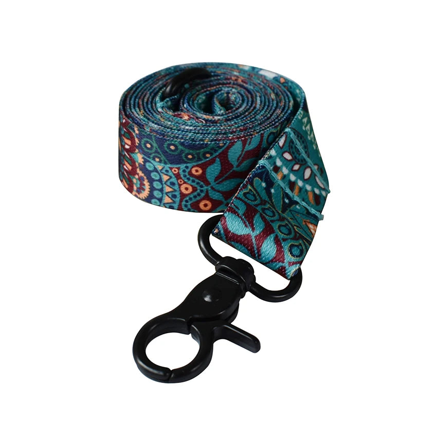 A rolled patterned fabric featuring teal, blue, and rust tones used for a personalized printed dog collar and leash set.