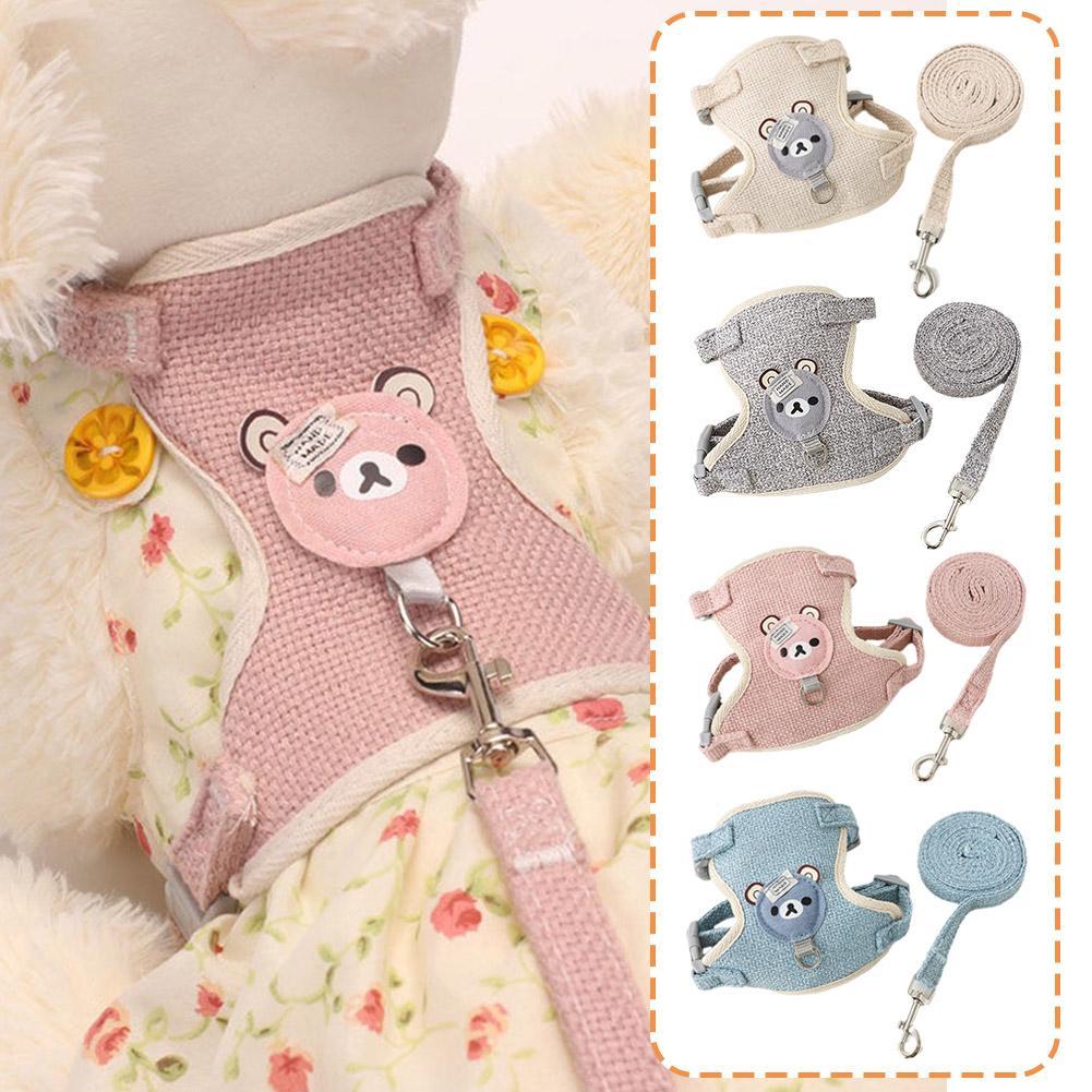 A collection of pink, gray, and blue pet leash harnesses for dogs and cats displayed on a fluffy white garment.