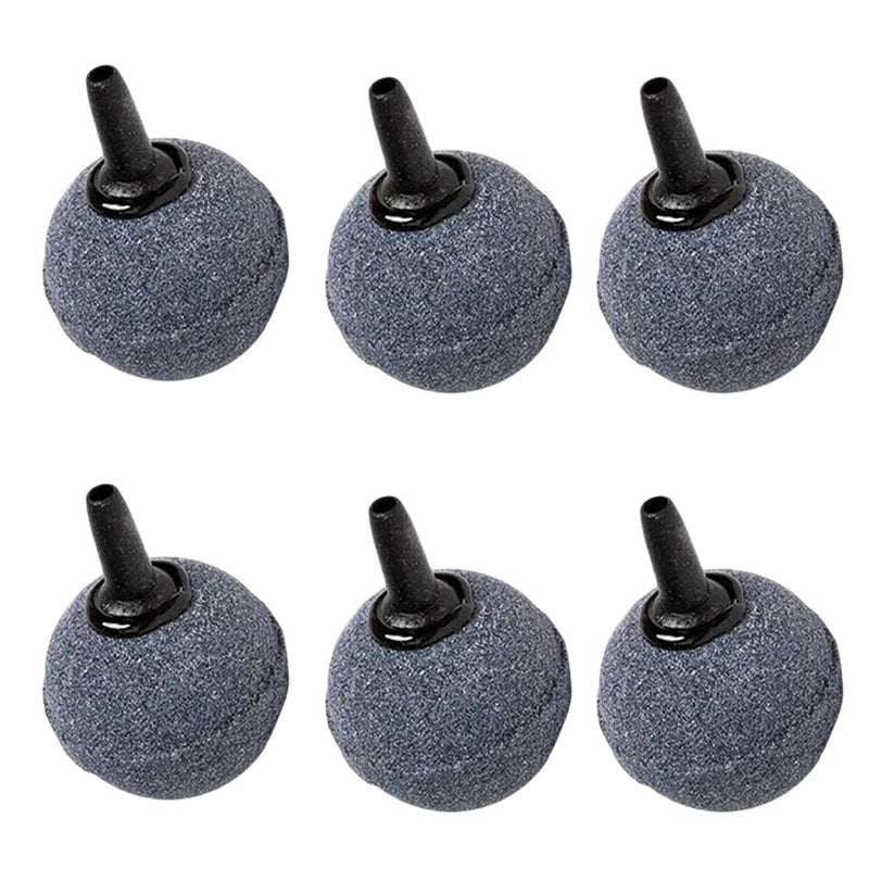 A set of five dark gray, round aquarium air stones with black nozzles.