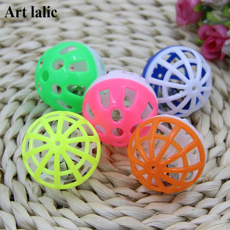 A collection of ten plastic cat ball toys in various colors including green, pink, blue, and orange resting on a woven mat.