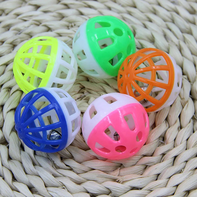 A collection of ten plastic cat ball toys in various colors including lime green, white, orange, and pink, resting on a woven