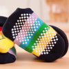 Colorful striped baby socks with a pattern of white dots and yellow accents