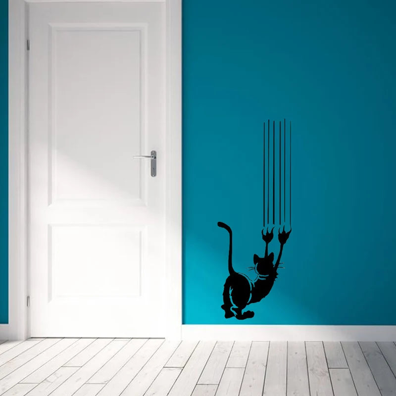 A white door with a blue wall featuring a black silhouette of a cat climbing down.