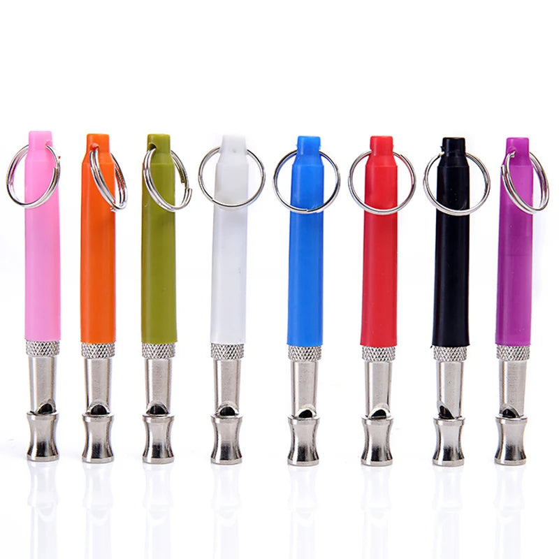 A row of colorful adjustable dog training whistles with metal clasps and lanyards.