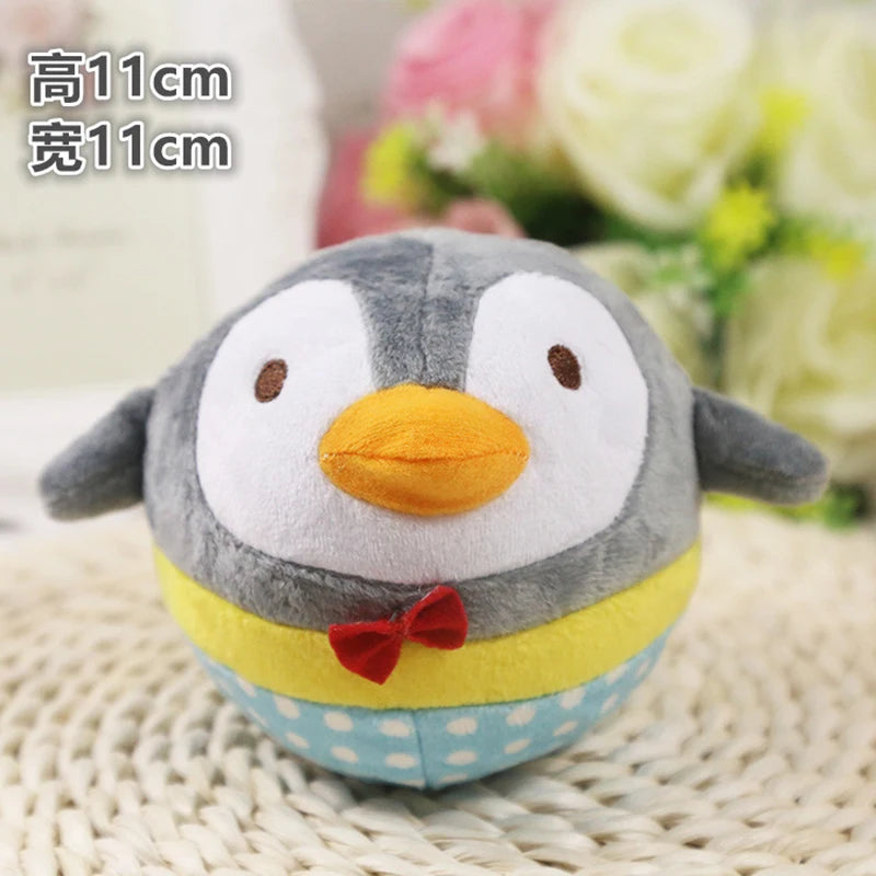 A cute plush penguin toy with gray and yellow coloring and a red bow, resting on a woven surface.