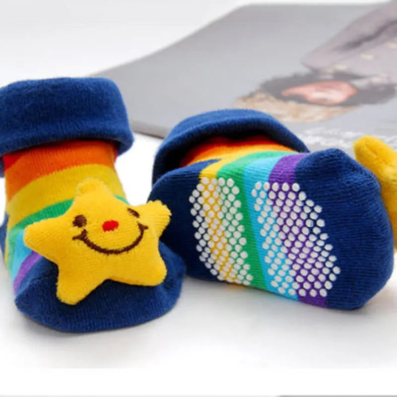A pair of colorful knitted baby socks featuring a yellow star design and rainbow stripes.