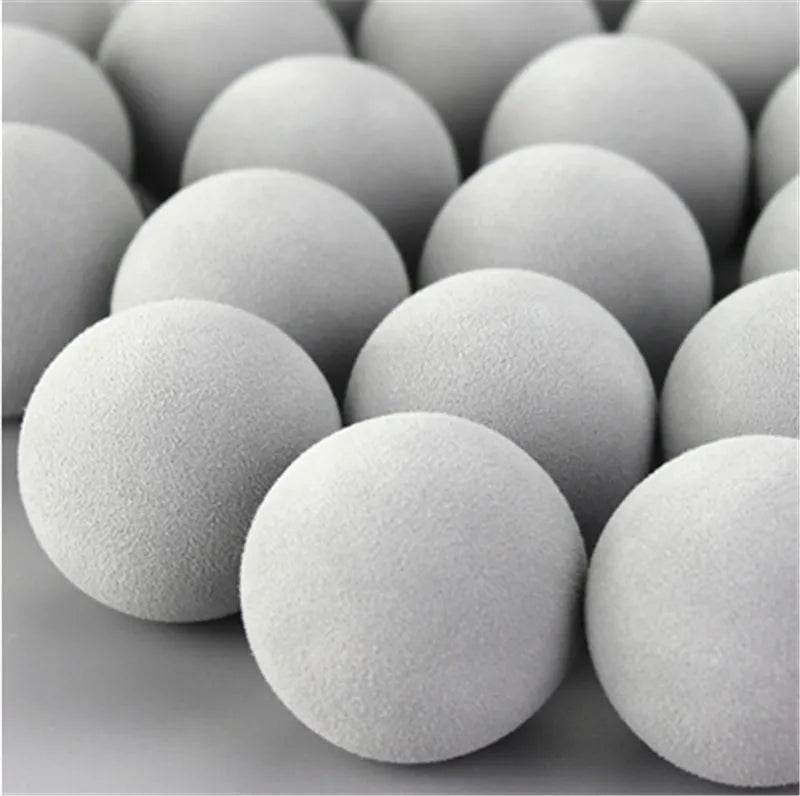 A close-up view of a pack of gray EVA foam practice golf balls arranged in a pile.
