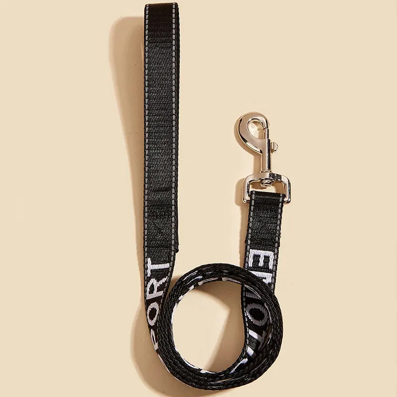 A black reflective service dog leash with a silver metal clip and padded neoprene handle.