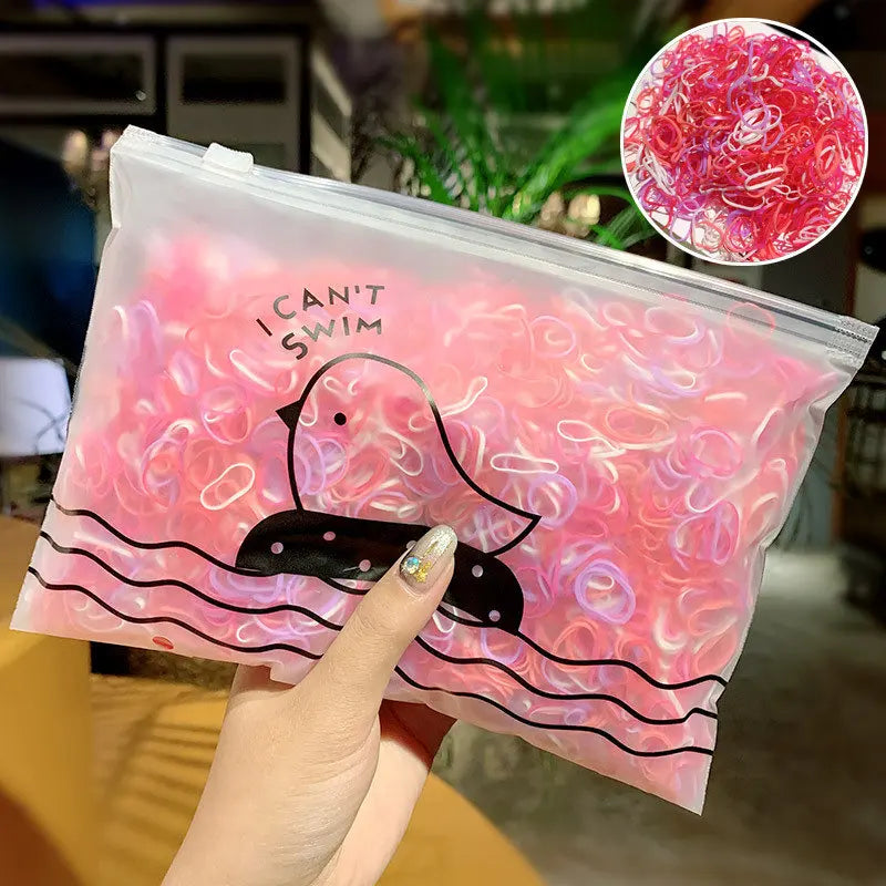 Klare Plastiktüte gefüllt mit rosa und weißen Gummibändchen mit einer Enten-Silhouette.