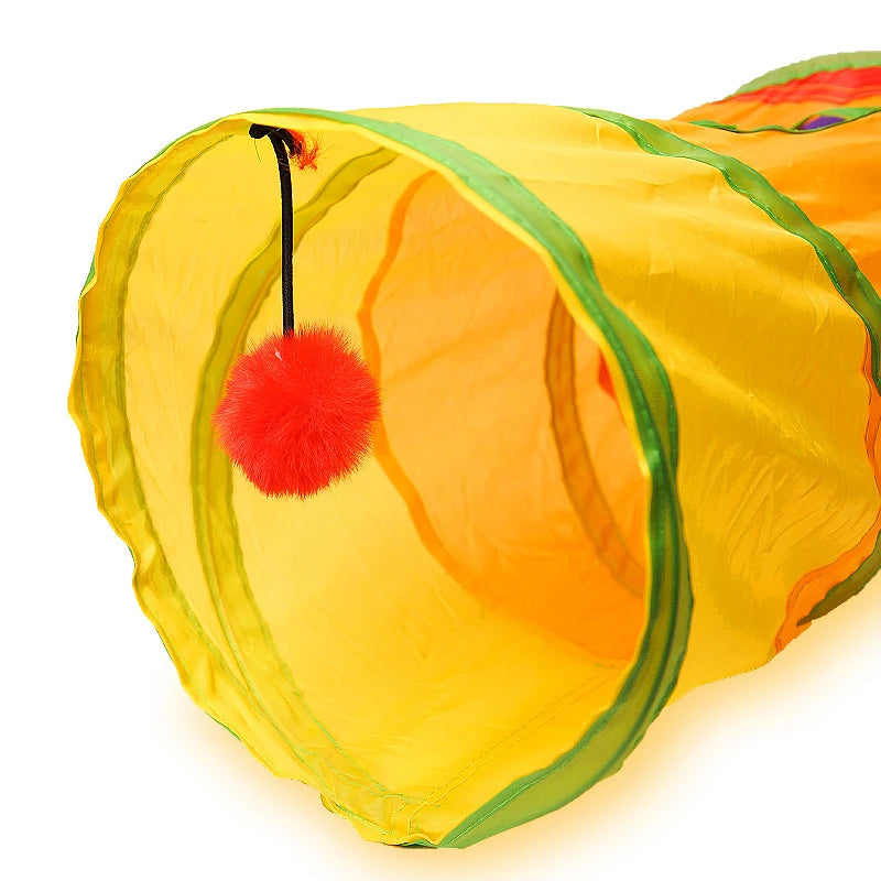 A bright yellow collapsible pet play tunnel with a green trim and a red pom-pom decoration.