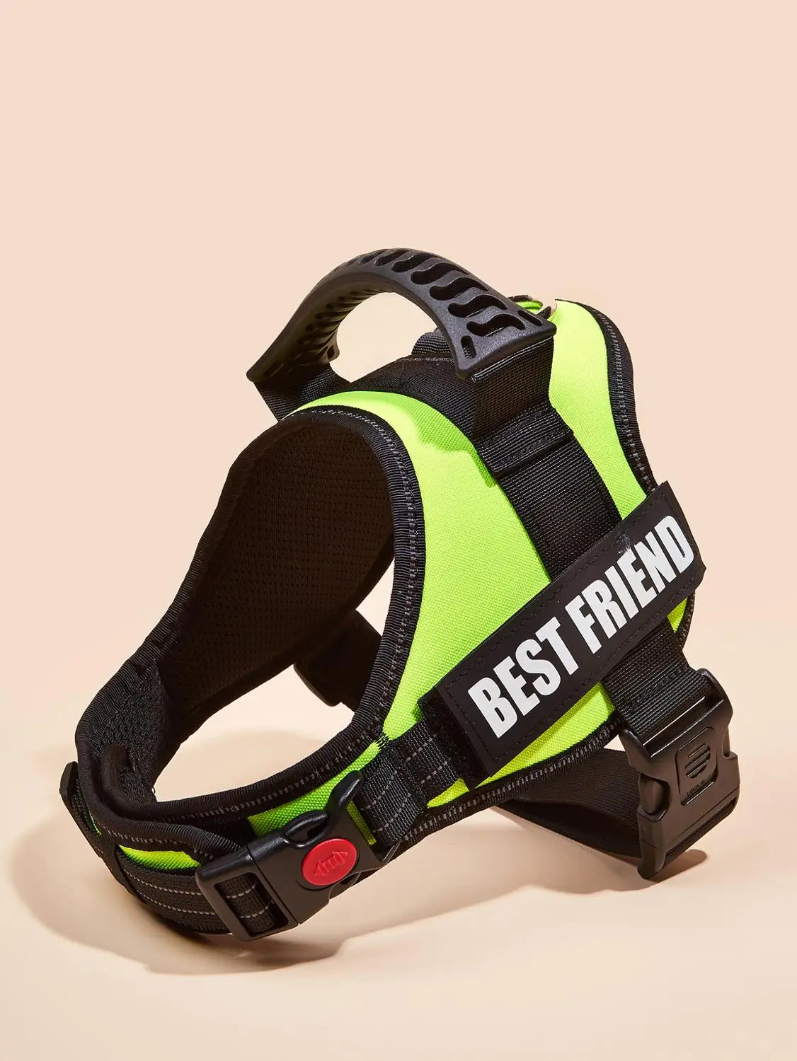 A bright lime green dog harness vest with black straps and a red ID tag is shown against a neutral background.
