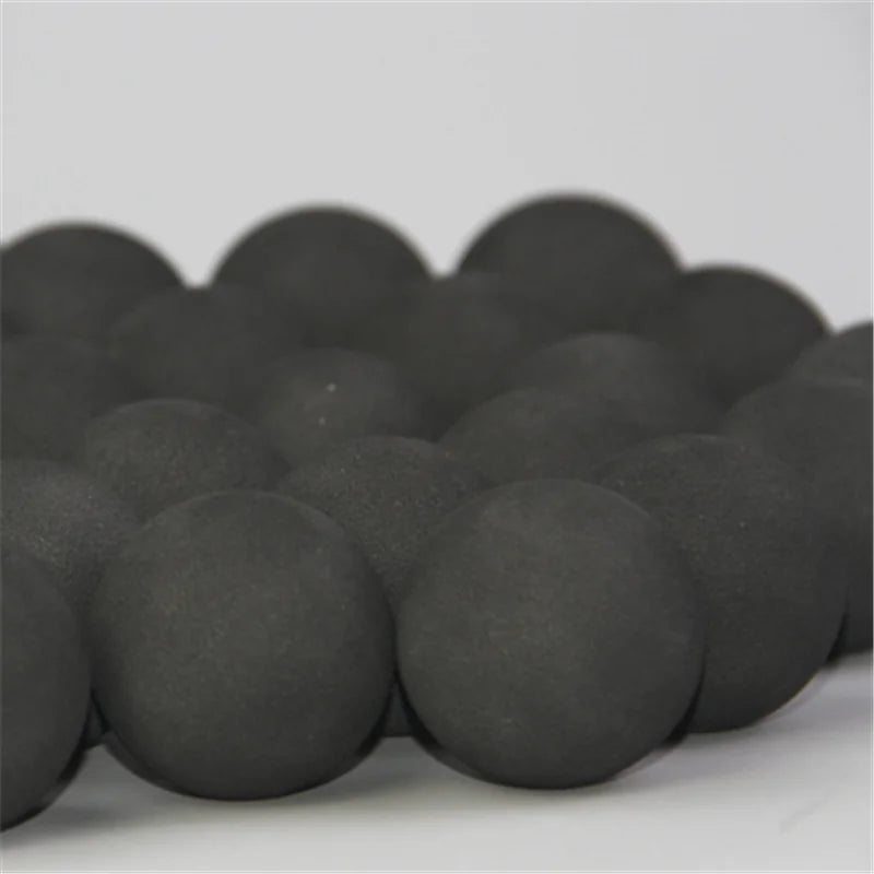 A pile of dark gray EVA foam practice golf balls for training.