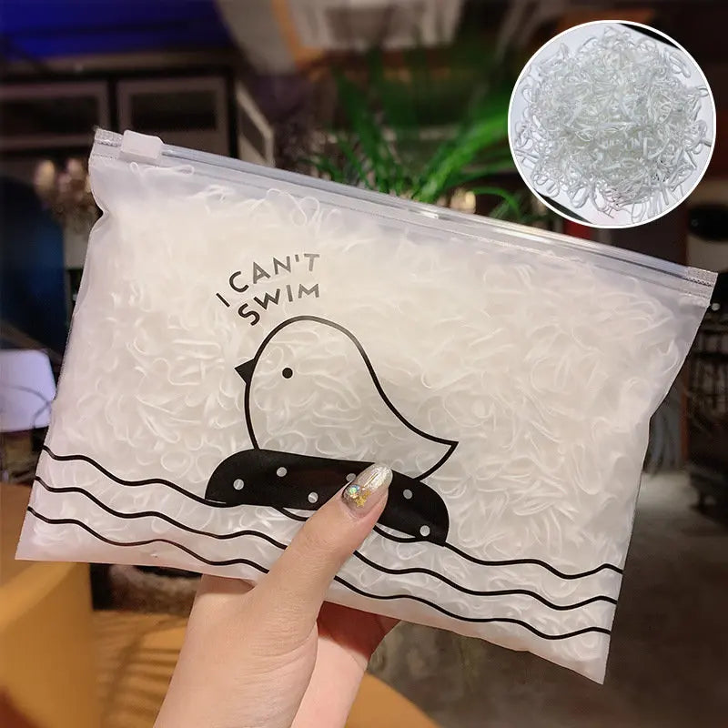 Eine Hand hält einen durchsichtigen Plastiksack mit weißen Gummihaar-Knoten und einer kreisförmigen Ansicht des Produkts.