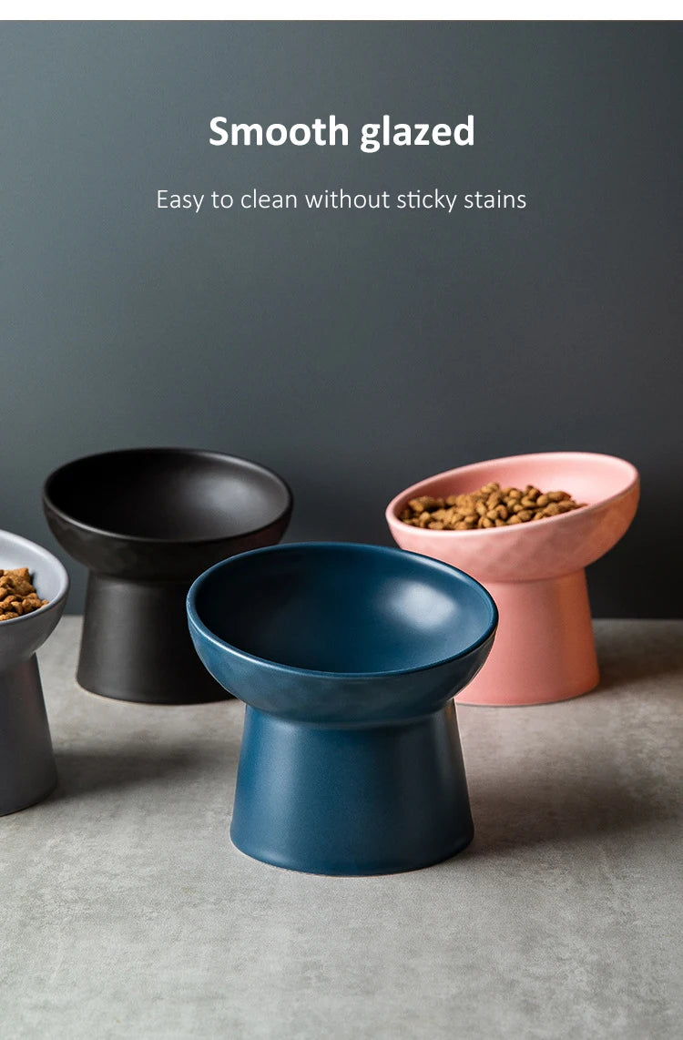 Three ceramic food bowls in black, blue, and pink are displayed on a gray surface.