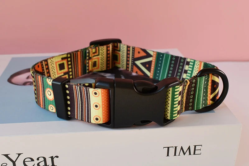 A personalized printed dog collar and leash set featuring colorful patterned fabric on a black leather strap.